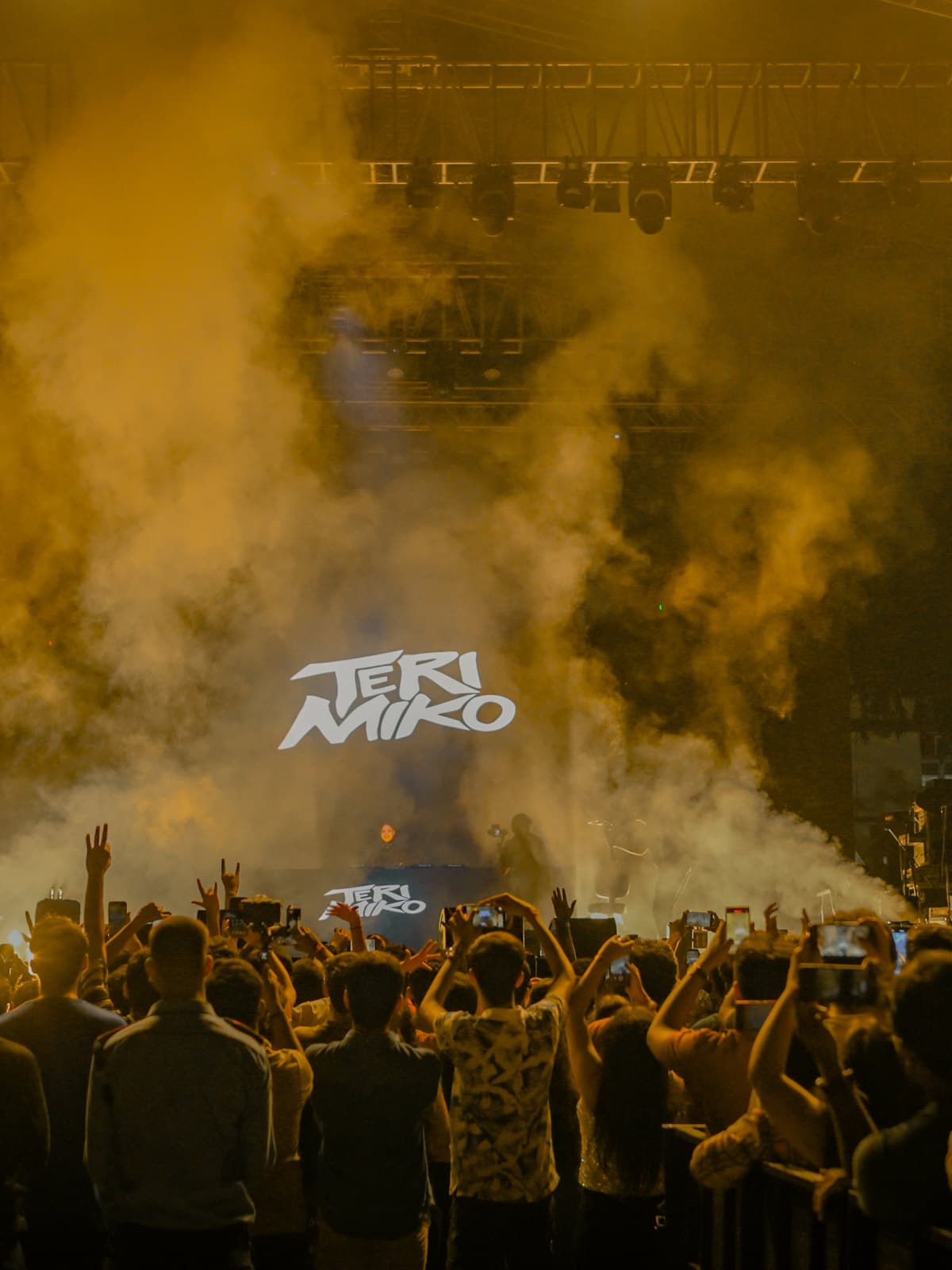 A pronite set under yellow smoke, the crowd lit from the stage