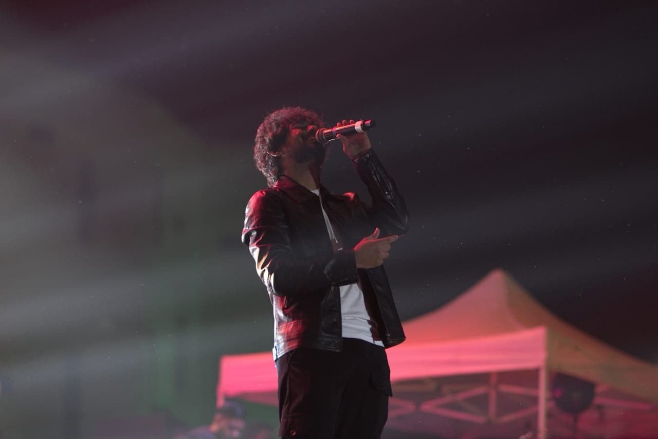A performer at the microphone under red light at the pronite